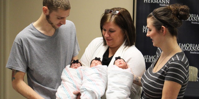 Proud Parents Brad and Stephanie Harris and grandmother Lynn Sweat holding (from left to right) identical triplets Savannah, Addison and Kinsley Harris.