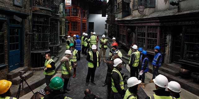 in this 2012 photo, press members and workers view "Diagon Alley" during a tour of the set of the Harry Potter films at the Warner Bros. Studios in Leavesden.