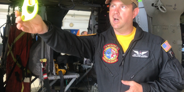Asheville firefighter and HART helicopter search and rescue technician Trey Young explains how rescuers hoist a basket down to victims in air rescues.