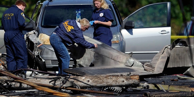 In this Oct. 12, 2016 file photo, investigators look at the remains of a small plane along Main Street in East Hartford, Conn.