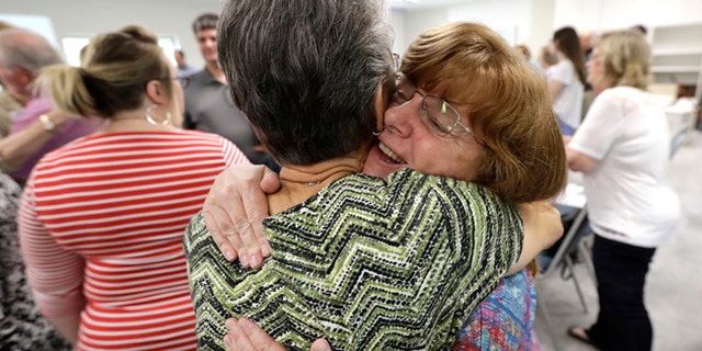 Chris Kaplan, right, hugs flood victim Betty Locklear during service at Christ United Church in the aftermath of Hurricane Harvey, Sunday, Sept. 3, 2017.