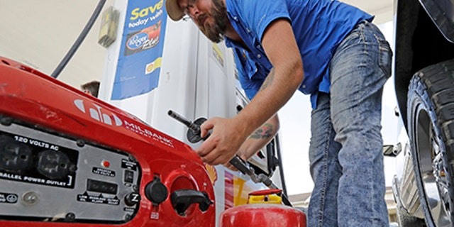 Aaron Berg fills up a gas can and his portable generator, Aug. 24, 2017.