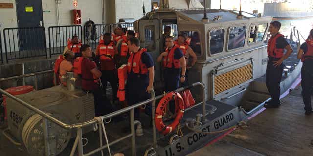 Jan. 22, 2015: Coast Guard crew members standing with 11 survivors of the Tug Nalani at Coast Guard Station Honolulu.