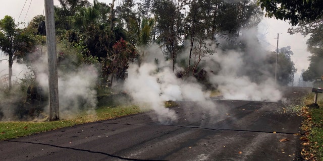 This May 7, 2018, file photo from the U.S. Geological Survey shows gas and steam rising from multiple fissures on Moku Street in the Leilani Estates Subdivision near Pahoa on the island of Hawaii.