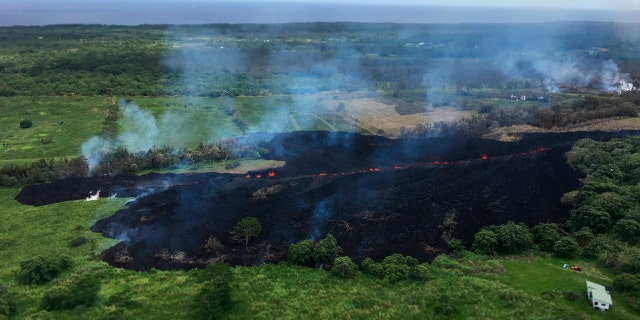 In this May 13, 2018 photo released by the U.S. Geological Survey, gases rise from a fissure near Pahoa, Hawaii.