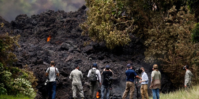 Members of the media record a wall of lava entering the ocean near Pahoa.