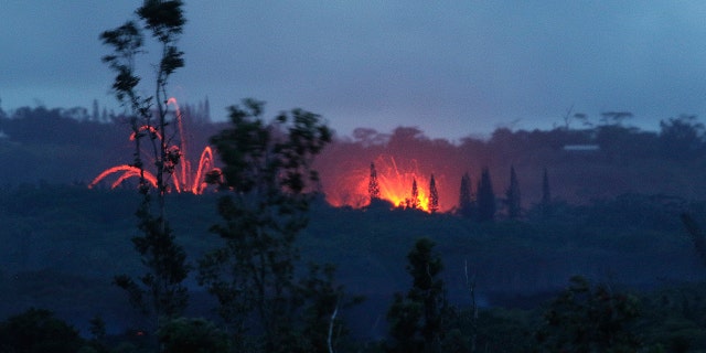 In this May 15, 2018 file photo, lava shoots into the night sky from active fissures on the lower east rift of the Kilauea volcano near Pahoa, Hawaii.