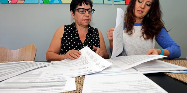 Ana Granado, left, and her daughter Andreia Walker, right, look over healthcare paperwork at their home in Charlotte, N.C., Wednesday, Feb. 10, 2016. Granado had health insurance through the federal health care law and was undergoing treatment for breast cancer when she found out her premiums were going up more than six-fold. Shes among hundreds of thousands of people whose coverage is jeopardized annually by paperwork problems. Hundreds of thousands of people lose subsidies under the health law, or even their policies, when they get tangled in a web of paperwork problems involving income, citizenship and taxes. (AP Photo/Chuck Burton)