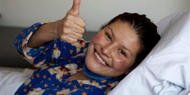 Erika Hernandez, 28, gives a thumbs up from inside an ambulance after being discharged from the hospital where she had a heart transplant in Mexico City, Tuesday Jan. 24, 2012. Hernandez made national news on Jan. 11 when her new heart was accidentally dropped while being transported to the hospital where she was waiting for surgery.