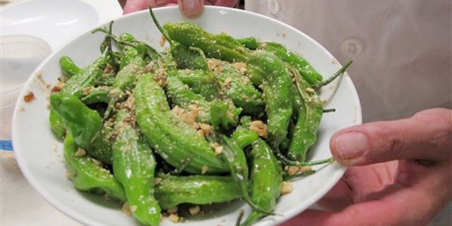 July 12, 2012: Chef Dan Jacobs holds a plate of shishito peppers at Roots Restaurant and Cellar in Milwaukee.