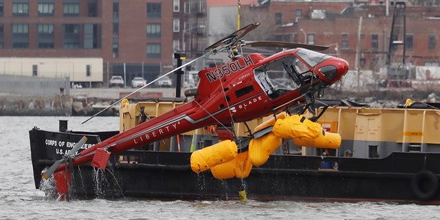 The wreckage of a chartered Liberty Helicopters helicopter that crashed into the East River during a photo shoot tour is hoisted from the water in New York City. (REUTERS/Shannon Stapleton)