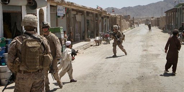 In this April 26 photo, U.S. Marines with the 3rd Battalion, 2nd Regiment patrol Nawzad's virtually empty bazaar in Helmand province south of Kabul, Afghanistan.