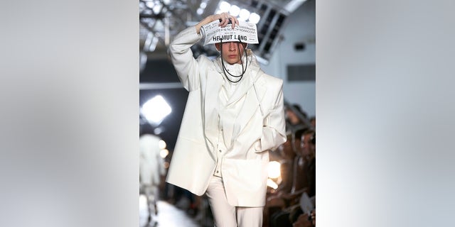 A model shields her eyes with a custom newspaper as she walks the runway at the Helmut Lang Seen by Shayne Oliver fashion show during Fashion Week, Monday, Sept. 11, 2017, in New York. (AP Photo/Kathy Willens)