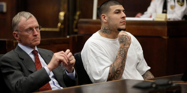 Former New England Patriots NFL football player Aaron Hernandez, center, sits with defense attorney Charles Rankin, left, while attending a pre-trial hearing at Suffolk Superior Court, Tuesday, Dec. 22, 2015, in Boston. Hernandez is charged with killing two Boston men in 2012 after a chance encounter at a nightclub. (AP Photo/Steven Senne, Pool)
