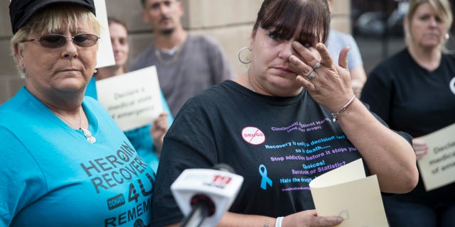 In this Sunday, Sept. 11, 2016, file photo, Christel Brooks, of Cincinnati, wipes a tear as she speaks to the media as heroin awareness and advocacy groups rally on the steps of the Hamilton County Justice Center to demand action after a wave of overdoses hit the region.
