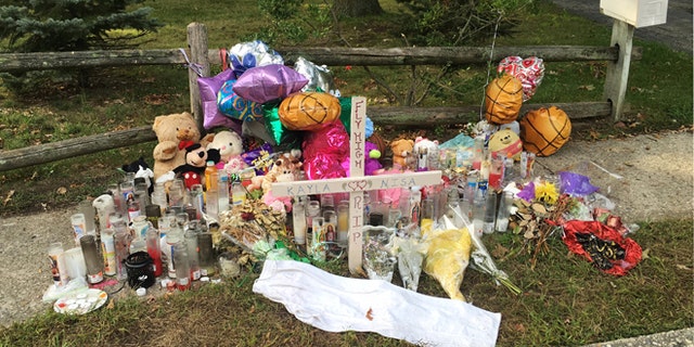 In this Sept. 27, 2016 photo, a memorial for Nisa Mickens and Kayla Cueva is located near the locations where their bodies were found in Brentwood, N.Y. The girls, who were best friends, were found murdered. Multiple teenagers from the same Long Island high school have been found dead and while police suspect all the deaths are related to gang violence, they are releasing few details.