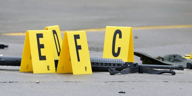 July 7, 2016: A weapon lays on the ground next to evidence markers in Bristol, Tenn. Three people were injured and one person was killed after a man opened fire on motorists traveling along a parkway in East Tennessee.