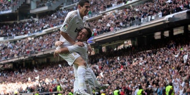 Real Madrid's Gonzalo Higuain from Argentina, bottom, reacts after scoring against Osasuna with Angel Di Maria from Argentina, right, during a Spanish La Liga soccer match at the Santiago Bernabeu stadium in Madrid, Sunday, Nov. 6, 2011. (AP Photo/Arturo Rodriguez)
