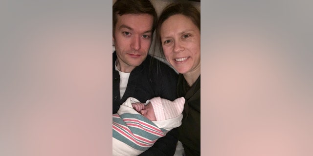 OB-GYN Hilary Conway is pictured with her husband and newborn daughter. She delivered her patient's twins just 14 hours after she gave birth.