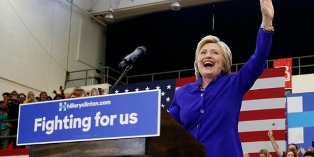 FILE – Democratic presidential candidate Hillary Clinton, left, reacts as she takes the stage at a rally, Monday, June 6, 2016, in Long Beach, Calif.