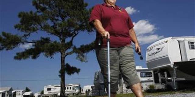 Harriet Bowen, who had hip replacement surgery, walks near her trailer at the Treasure Beach trailer park in Selbyville, Delaware, June 27, 2012. REUTERS/Tim Shaffer