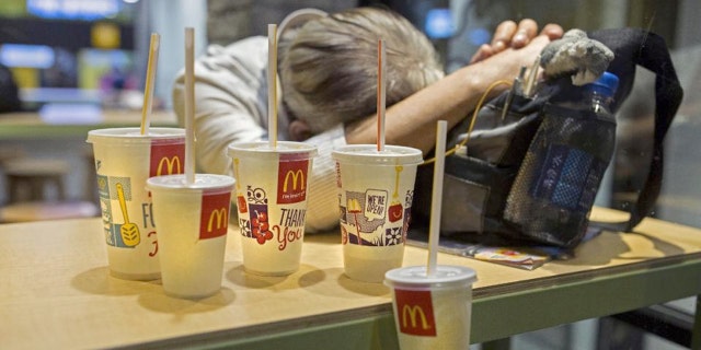 A man sleeps with his belongings at night in a 24-hour McDonald’s branch in Hong Kong.