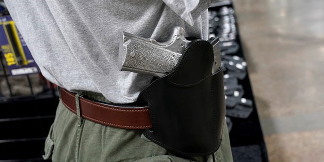 A concealed carry holster is displayed for sale at a gun show.