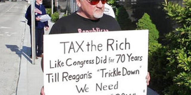 In this undated file photo, James Hodgkinson holds a sign during a protest outside of a United States Post Office in Belleville, Ill. Hodgkinson has been identified as the suspect in the Wednesday, June 14, 2017, Washington D.C. shooting. (Derik Holtmann/Belleville News-Democrat via AP)