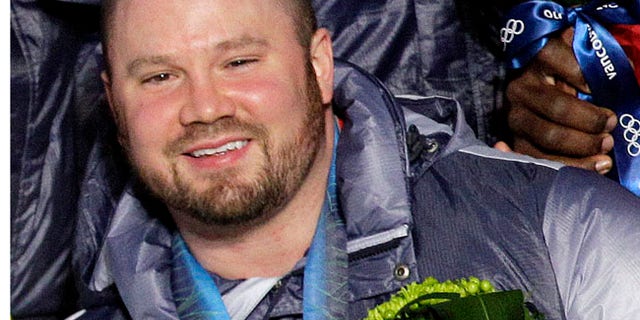 FILE - In this Feb. 27, 2010, file photo, Steven Holcomb, of the United States, poses with his gold medal in the men's four-man bobsled during the medal ceremony at the Vancouver 2010 Olympics in Whistler, British Columbia. Holcomb, the longtime U.S. bobsledding star who drove to three Olympic medals after beating a disease that nearly robbed him of his eyesight, was found dead in Lake Placid, N.Y., on Saturday, May 6, 2017. He was 37. (AP Photo/Jin-man Lee, File)