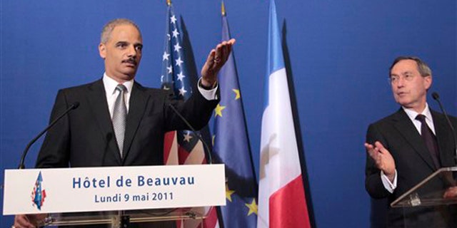 Attorney General Eric Holder, left, gestures during a press conference following a meeting with French Interior Minister Claude Gueant in Paris May 9.