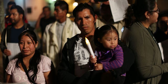 HOMESTEAD, FL - JANUARY 06: Marvin Pablo, originally from Guatemala, holds his daughter Lindsey Pablo as they join with others to protest against the deportation of undocumented immigrants on January 6, 2016 in Homestead, Florida. President Barack Obama's administration has begun a series of large-scale raids against hundreds of undocumented immigrants across the US, which is generating outrage among pro-immigrant groups who reject the measure. (Photo by Joe Raedle/Getty Images)