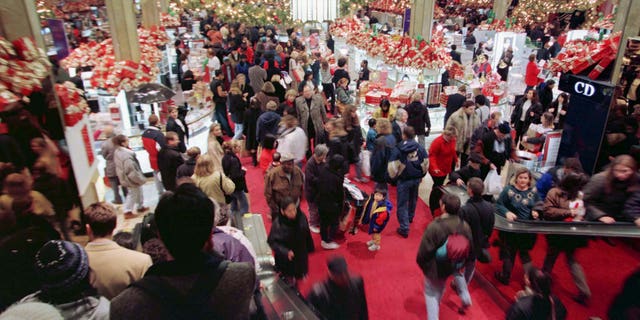 Shoppers careen through the main floor at Macy's department store in New York on November 28, the official start of the holiday shopping season. Retailers dub the day "Black Friday" in hope that sales will turn into the black ink of profits for the all-important retail season. - RTXH3SJ
