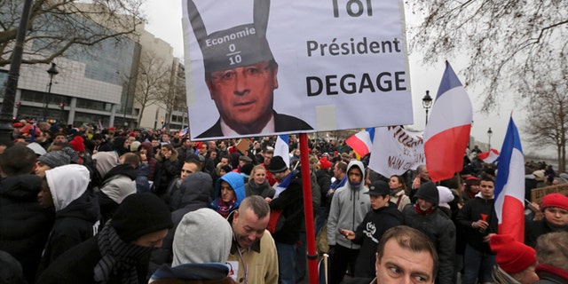 Jan. 26, 2014: Demonstrators gather near a sign portraying French President Francois Hollande wearing donkey ears with a school grade of Zero and which reads "You, President Resign" as several thousand people attend the "Journee de la Colere" (Day of Anger) march in Paris.