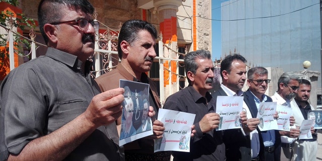 Survivors of the Halabja gas attacks hold pictures of relatives killed.
