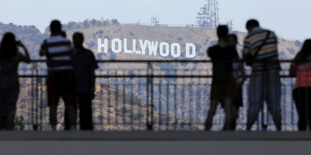 FILE -- Tourists take pictures of the Hollywood sign from a shopping complex along Hollywood Boulevard in Hollywood, California, August 3, 2017.