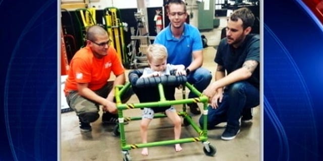 Silus Johnson, 2, tries out brand-new, custom-made walker built by some North Texas Home Depot employees. (Fox4 Dallas)
