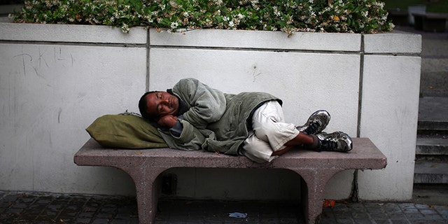 A man sleeps on a bench in downtown Los Angeles, California, May 31, 2017