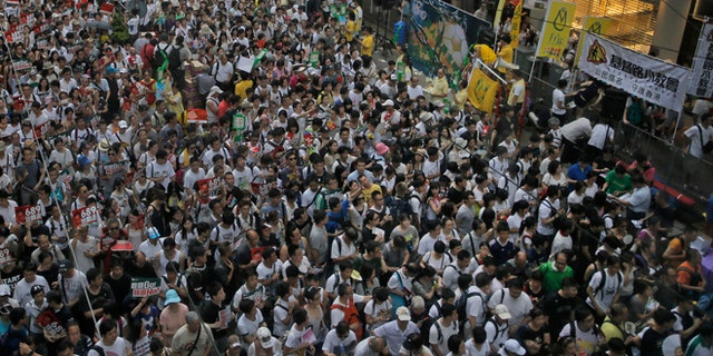 July 1, 2014: Tens of thousands of people fill in a street during a march at an annual protest in downtown Hong Kong. Hong Kong residents marched through the streets of the former British colony to push for greater democracy in a rally fueled by anger over Beijing's recent warning that it holds the ultimate authority over the southern Chinese financial center.