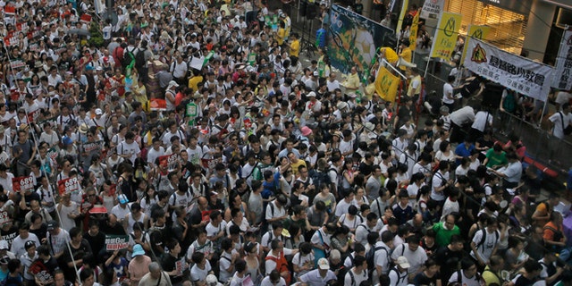 July 1, 2014: Tens of thousands of people fill in a street during a march at an annual protest in downtown Hong Kong. Hong Kong residents marched through the streets of the former British colony to push for greater democracy in a rally fueled by anger over Beijing's recent warning that it holds the ultimate authority over the southern Chinese financial center.