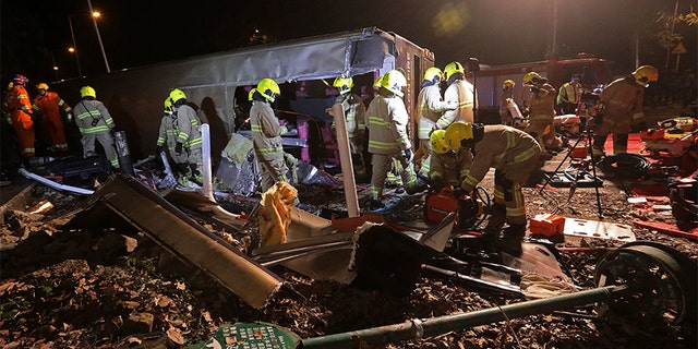 Firemen work at the scene of a bus crash in Hong Kong, Saturday, that killed 18 people.