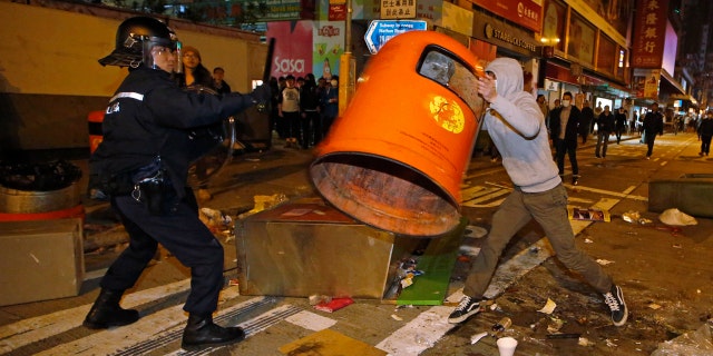 Feb. 9, 2016: A rioter tries to throw a litter bin at police on a street in Mong Kok district of Hong Kong. (AP Photo/Kin Cheung)