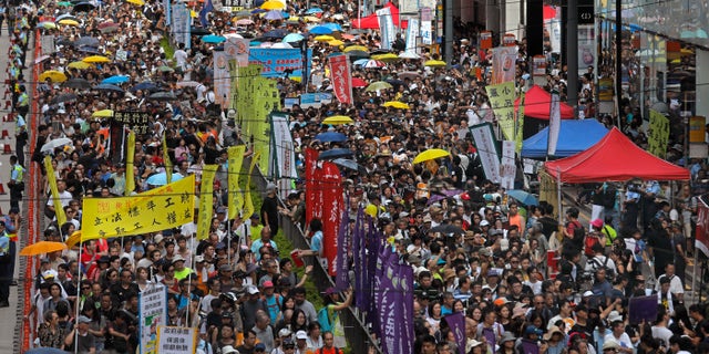 Thousands of protesters march along a downtown street during an annual pro-democracy protest in Hong Kong Sunday, July 1, 2018.