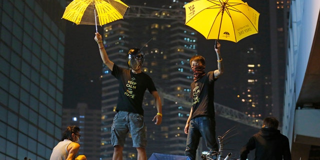 Dec. 10, 2014: Protesters pose for photographs on a barricade at the occupied area outside government headquarters in Hong Kong. (AP)