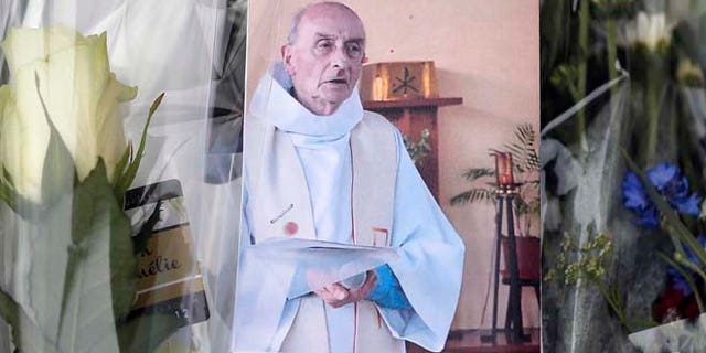 A picture of late Father Jacques Hamel is placed on flowers at the makeshift memorial