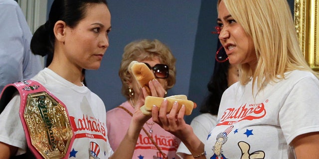 July 3, 2014: New York City Mayor Bill de Blasio watches hot dog eating contestants Sonya Thomas, left, and Miki Sudo, right, during a news conference to promote the upcoming Nathan's Famous Fourth of July Hot Dog Eating Contest.