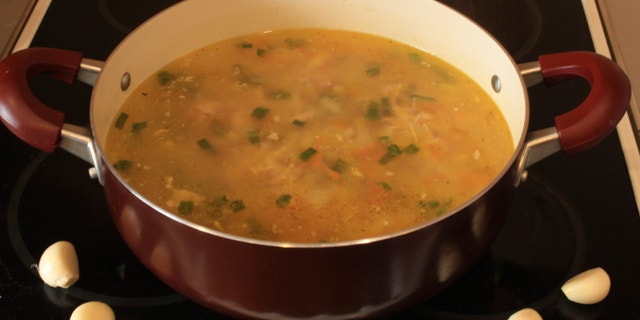 Fresh delicious pot of soup on the stove and garlic
