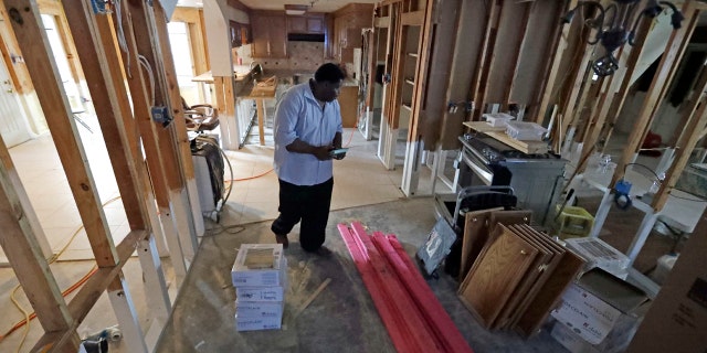 In this Nov. 17, 2017 photo, George Dorsey walks through his hurricane-damaged home in Houston. He usually hosts a large Thanksgiving dinner for family but is making other arrangements this year as he continues to recover from Hurricane Harvey.
