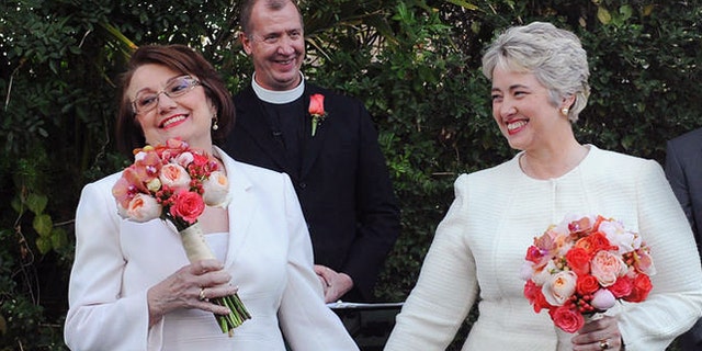 In this photo provided by the Houston mayor's office, Houston Mayor Annise Parker, right and her long-time partner, First Lady Kathy Hubbard, celebrate at their wedding Thursday, Jan 16, 1014 in Palm Springs, Calif. The ceremony was performed by the Rev. Paul Fromberg, rear, rector of St. Gregory of Nyssa Episcopal Church in San Francisco. (AP/Houston Office of The Mayor, Richard Hartog)