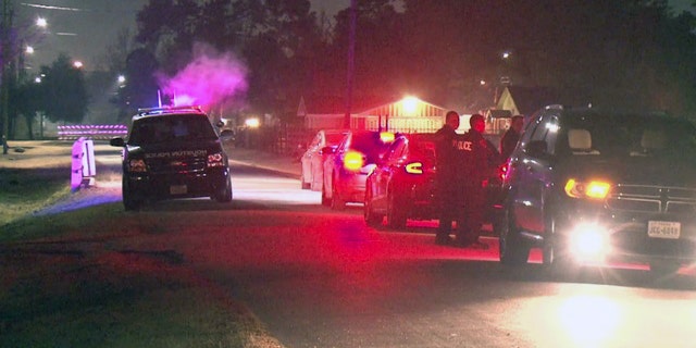 Law enforcement officers wait outside the Houston home where a kidnapping victim was killed early Thursday.