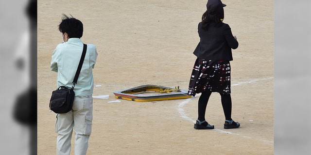 A fallen window frame of U.S. military aircraft is seen on the ground at an elementary school in Ginowan, Okinawa.